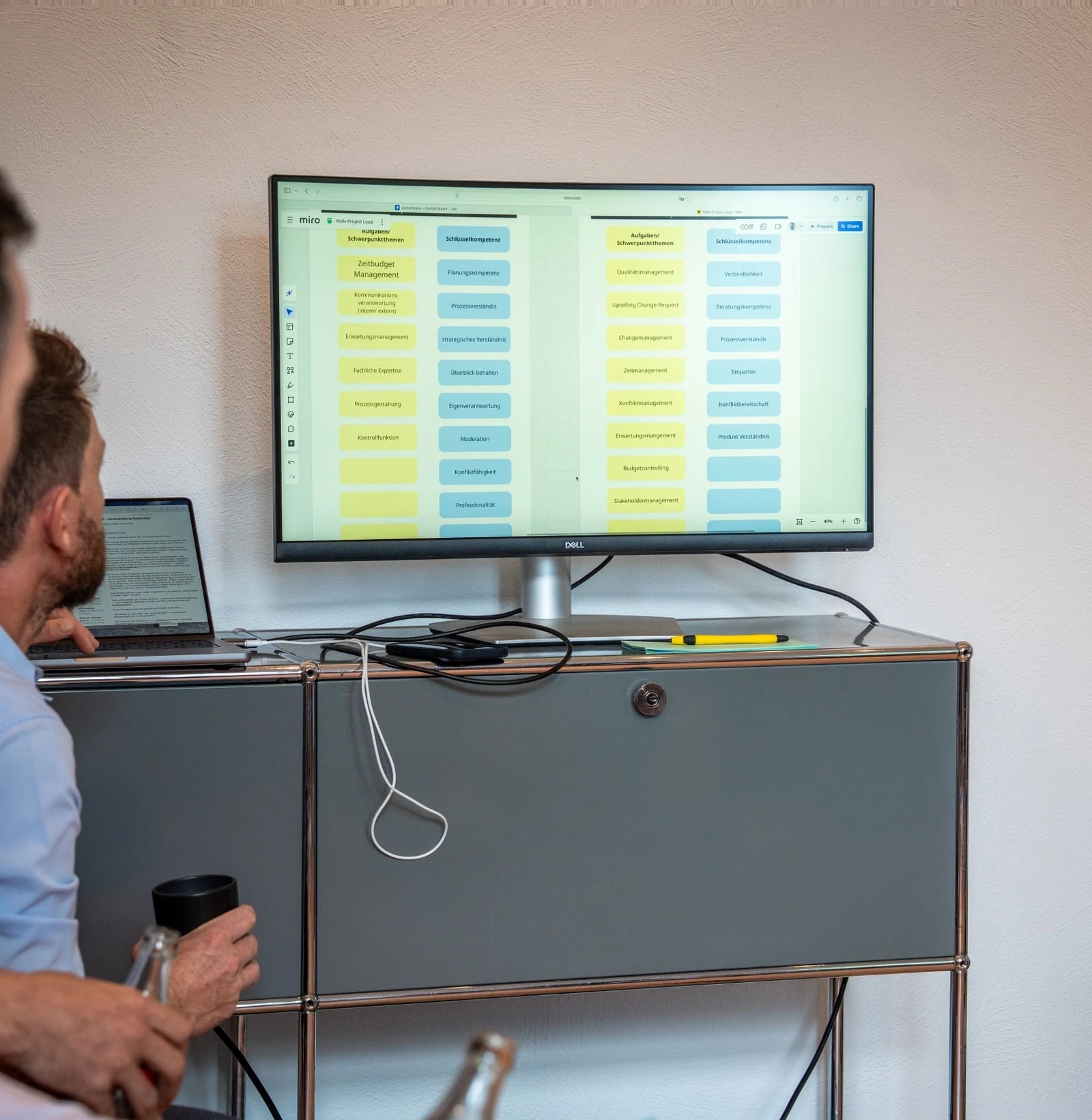 Mann betrachtet Projektplan auf großem Monitor