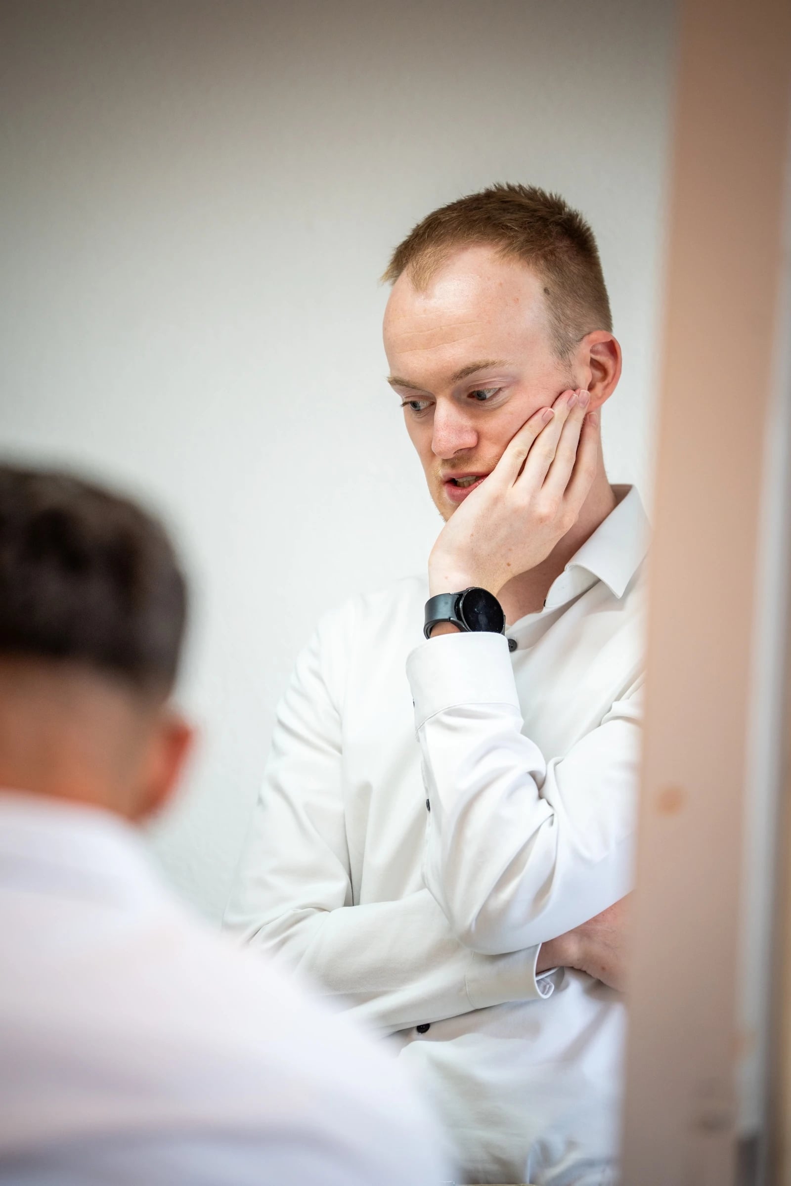 Nachdenklicher Mann im weißen Hemd im Büro