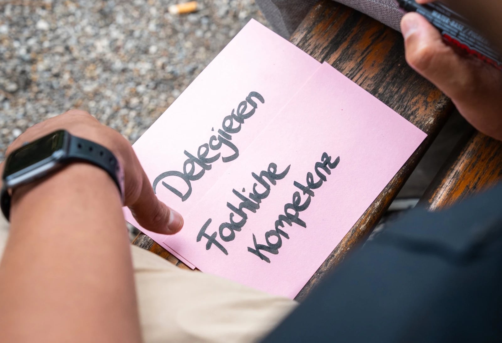 Hand hält Zettel mit „Fachliche Kompetenz“
