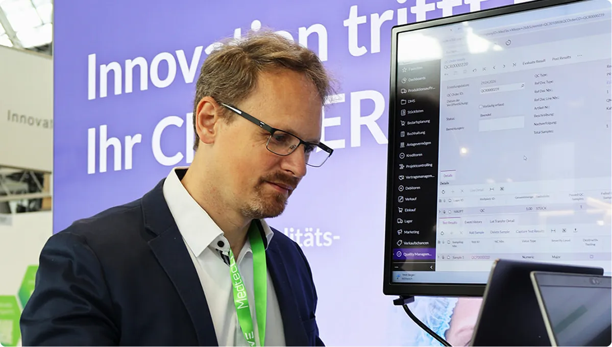 Mann am Messestand vor Computerbildschirm
