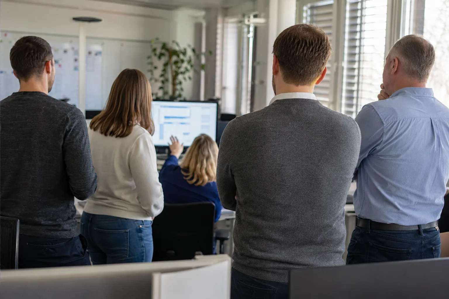 Projektteam steht im Workshop gemeinsam vor einem Whiteboard