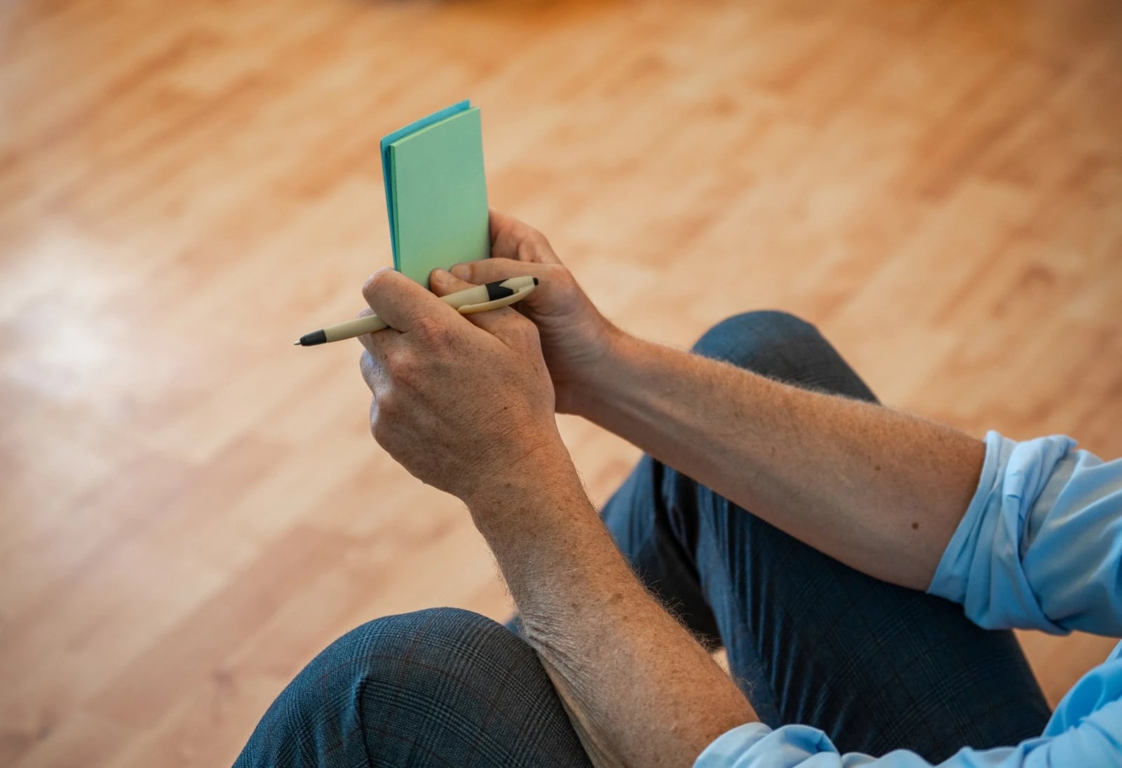 Person mit Notizbuch und Stift in Händen