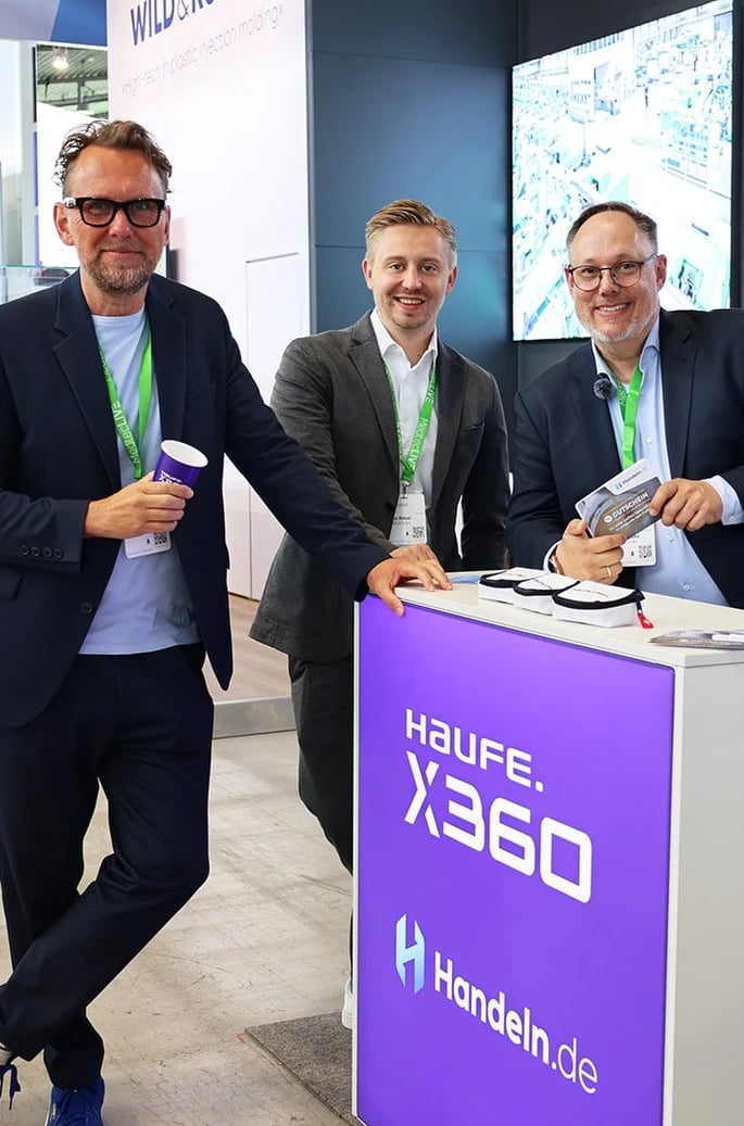 Drei Männer am Messestand von Haufe X360