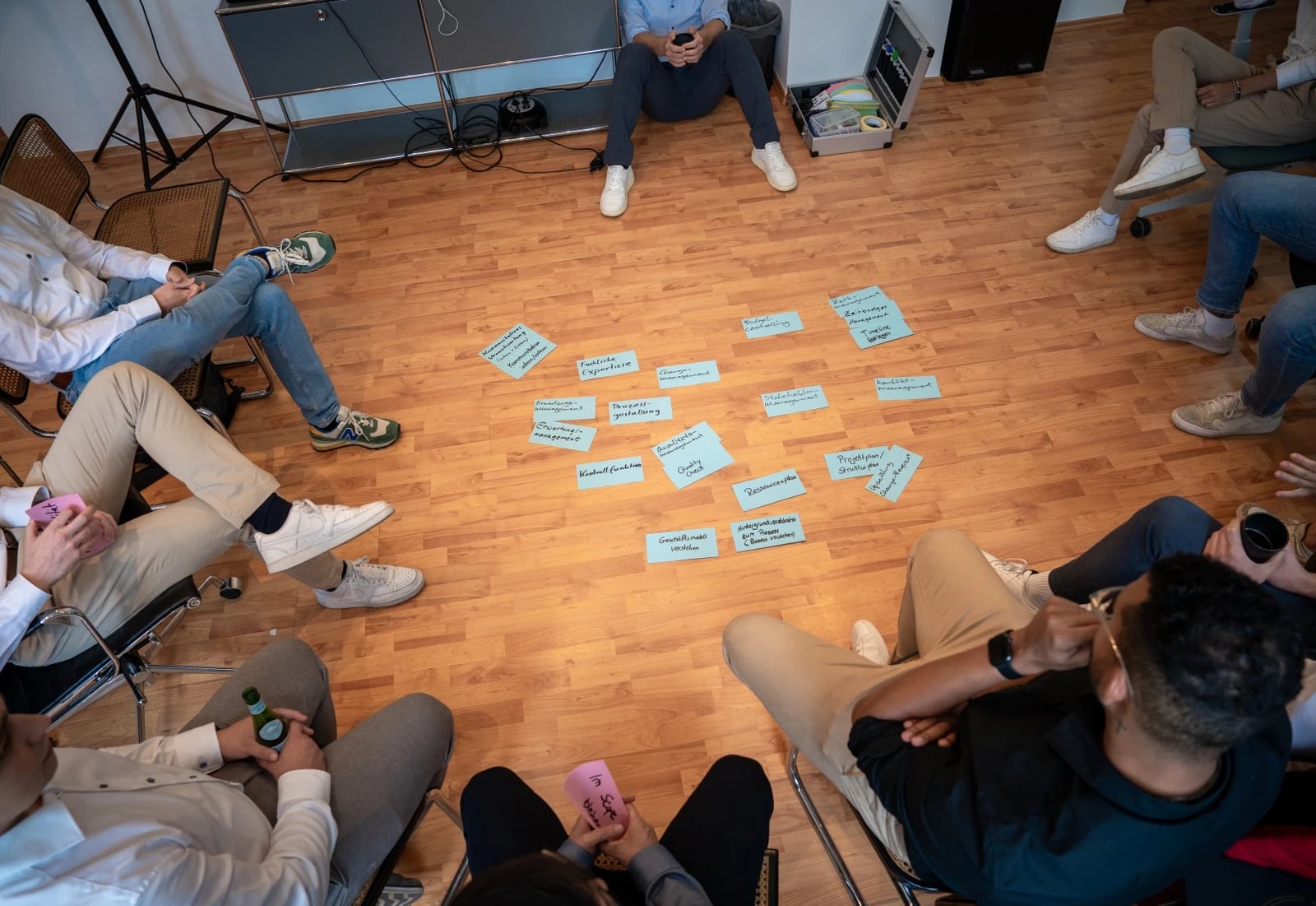 Gruppe sitzt im Kreis bei Workshop mit Karten