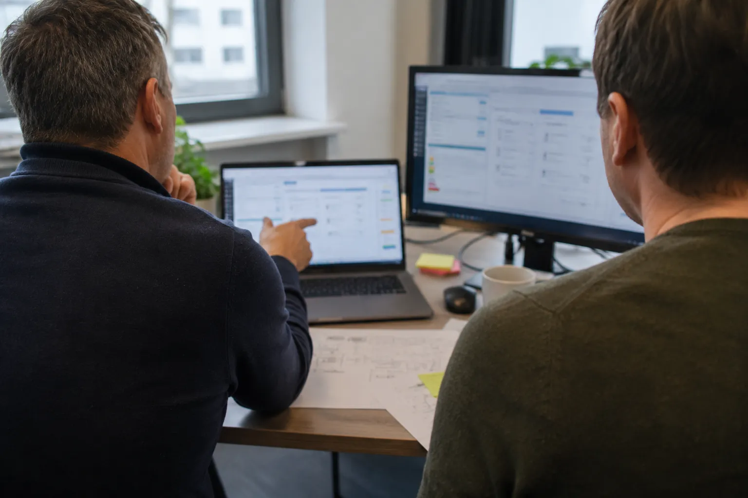 Zwei Kollegen besprechen eine Auswertung am Bildschirm