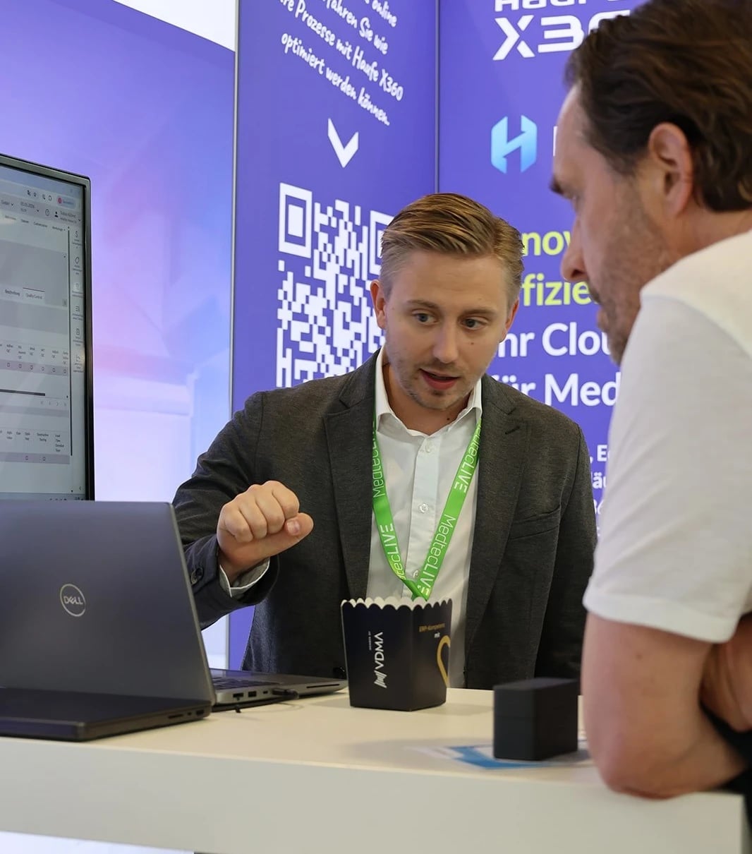 Beratungsgespräch am Messestand mit Laptop