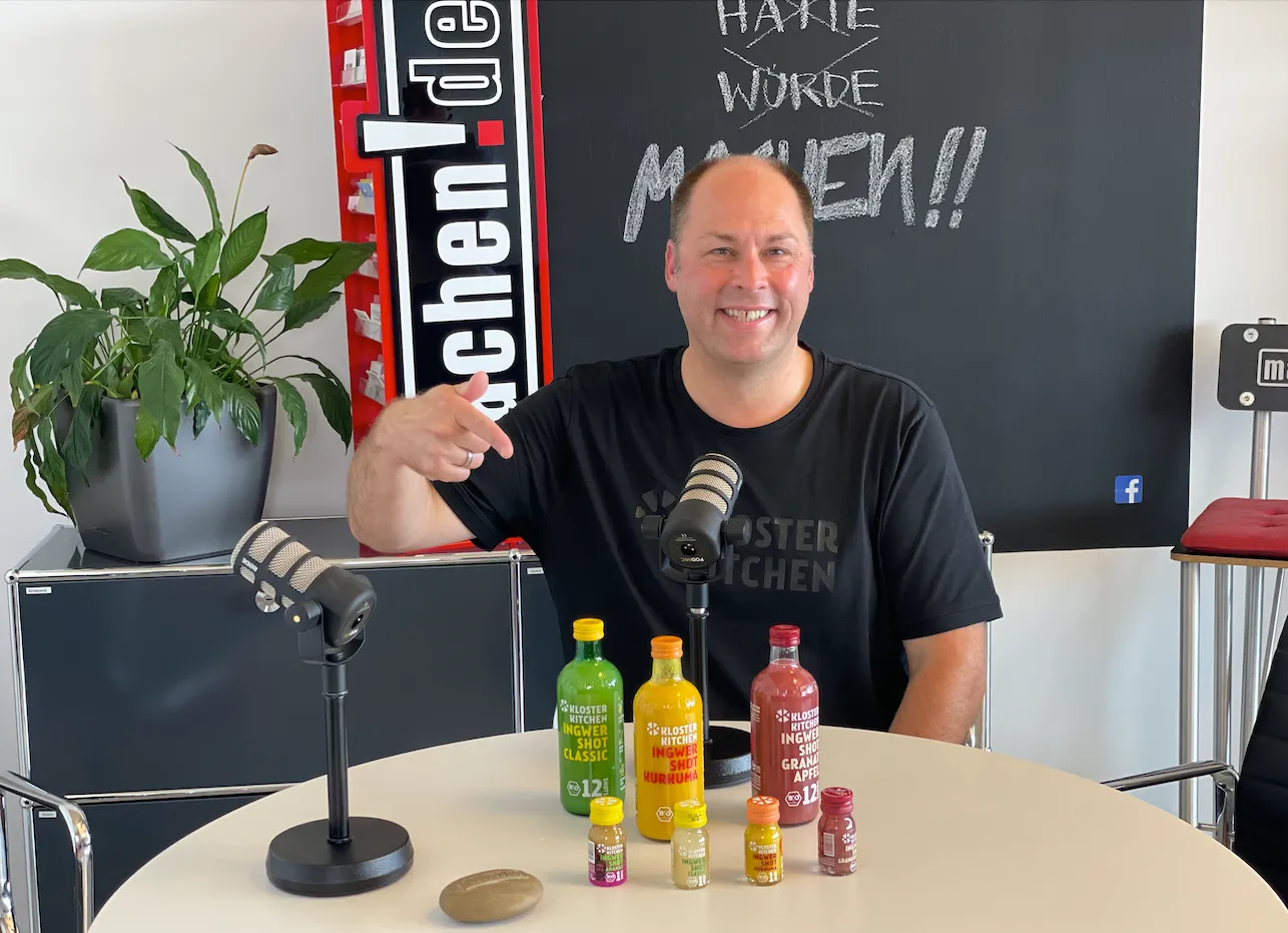 Mann mit Ingwer-Shots vor Mikrofonen