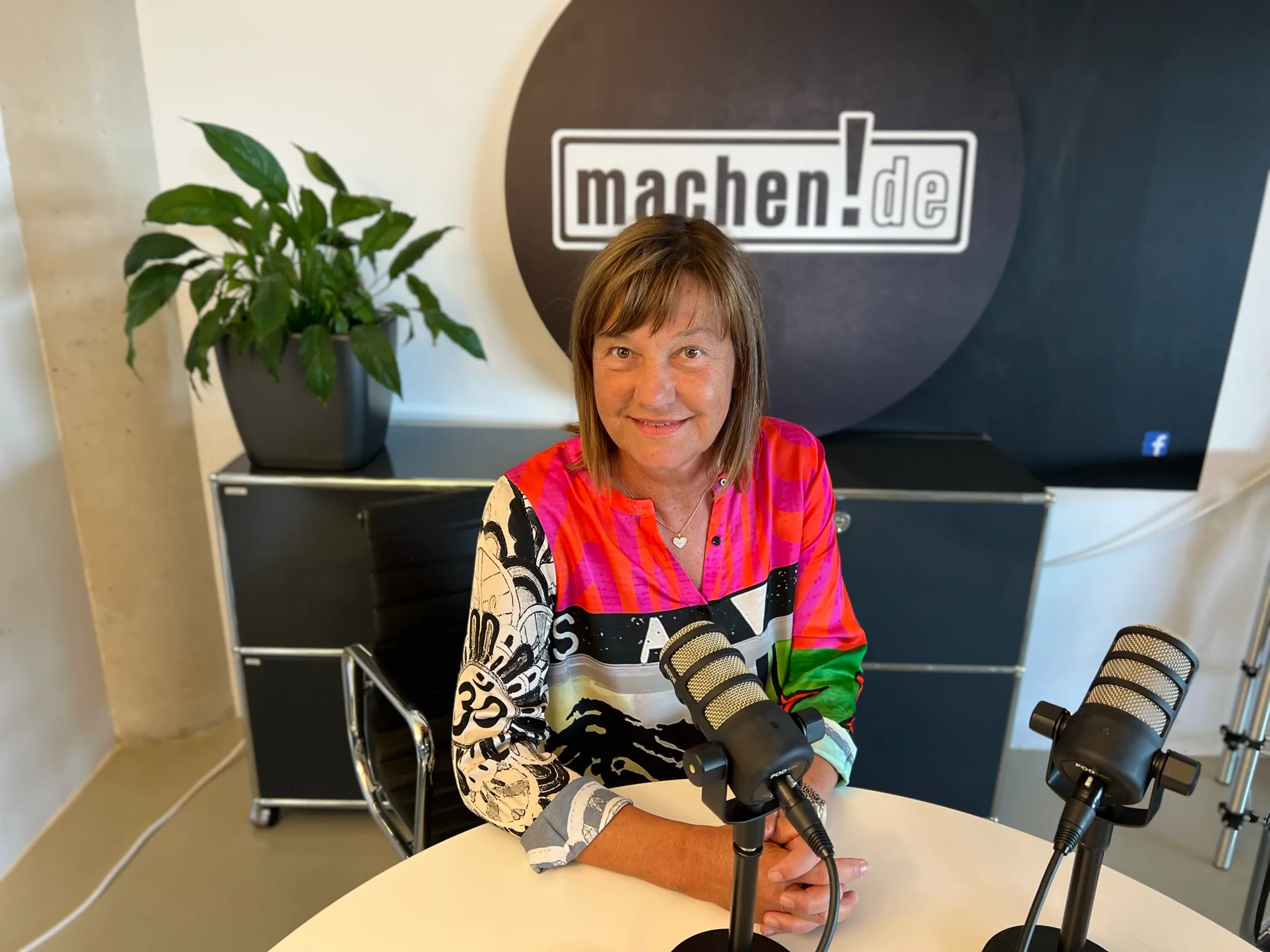 Frau im Podcaststudio mit Mikrofonen
