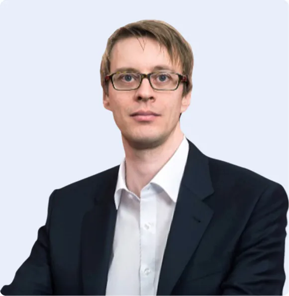 Mann mit Brille im Anzug vor hellem Hintergrund