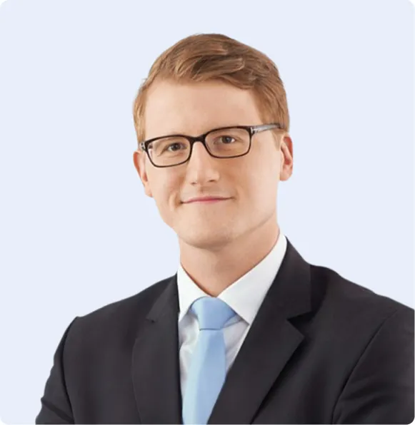 Mann im Anzug mit Brille vor hellem Hintergrund