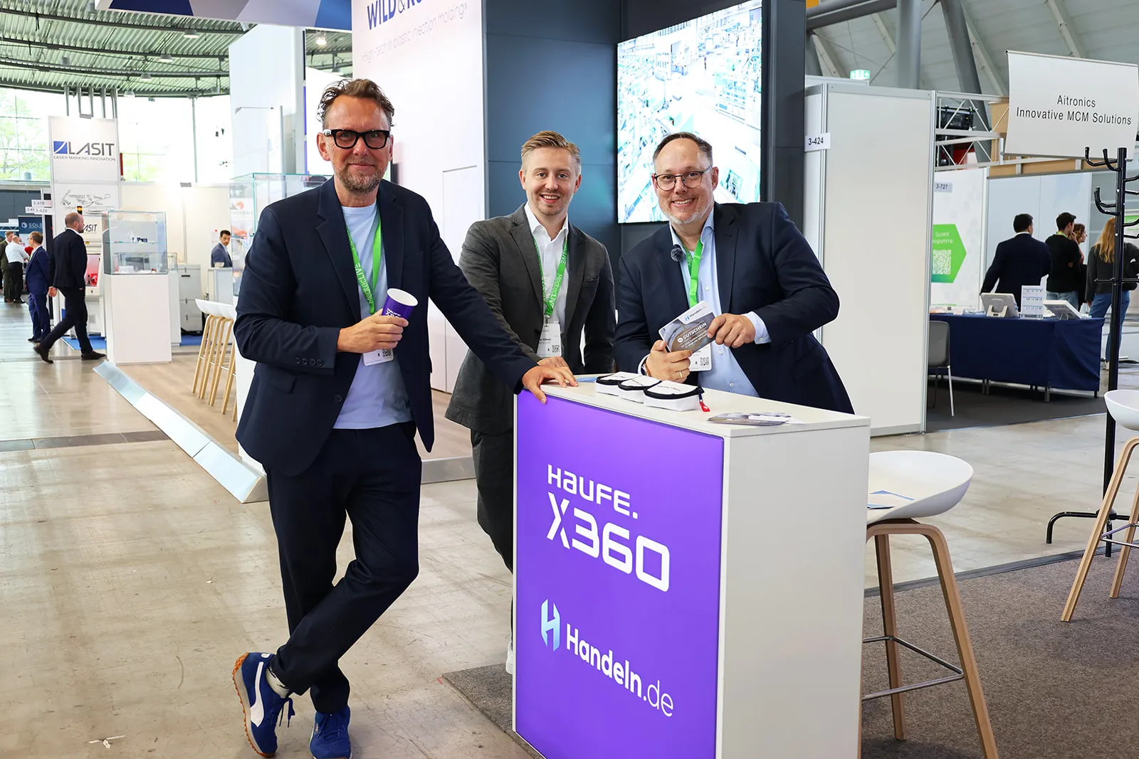 Drei Männer am Messestand von Haufe X360